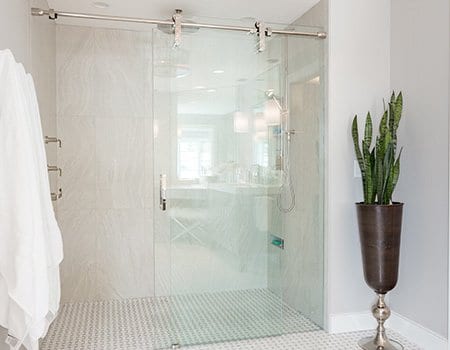 New luxury bathroom with white tiles and glass shower door