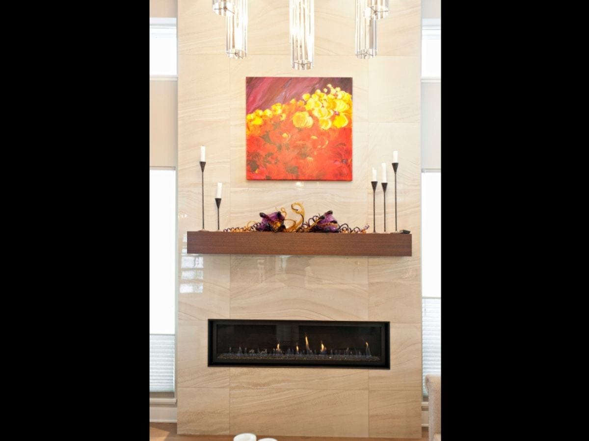 Piece of brightly colored art hung above a fireplace